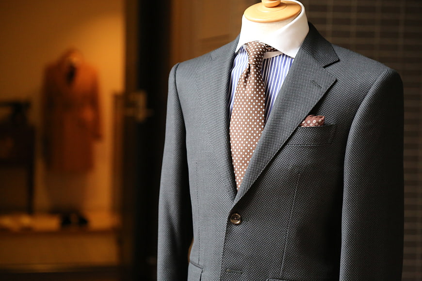 Gray textured suit with polka dot tie on mannequin