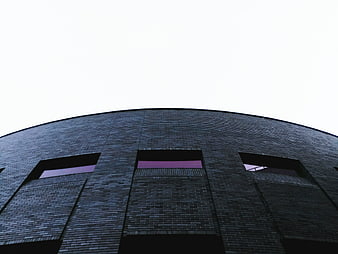 Low angle view of modern curved dark brick building facade