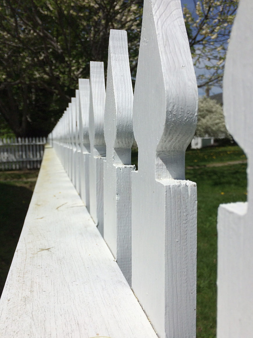 Close-up of white picket fence with leading lines