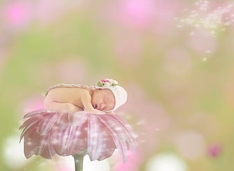Sleeping newborn baby on pink flower fantasy background