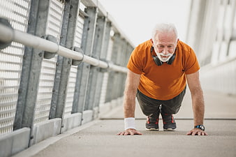 Senior man doing push-ups on outdoor bridge