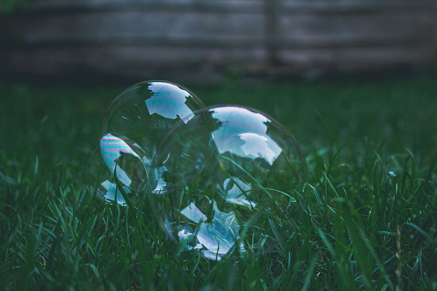Soap bubbles resting on green grass lawn