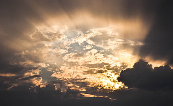 Dramatic Sunbeams Breaking Through Dark Clouds at Sunset