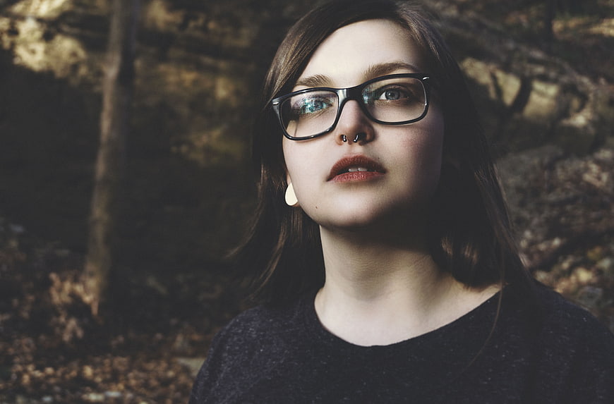 Portrait of young woman with glasses in forest
