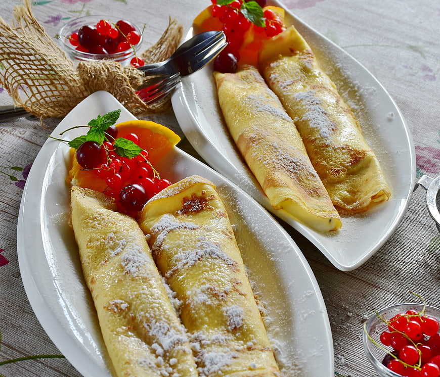 Golden Rolled Crepes With Red Currants And Powdered Sugar