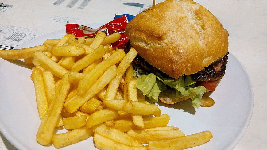Delicious burger and french fries on a white plate