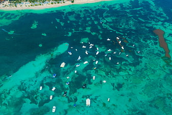 Aerial view of turquoise ocean with boats and coral reefs