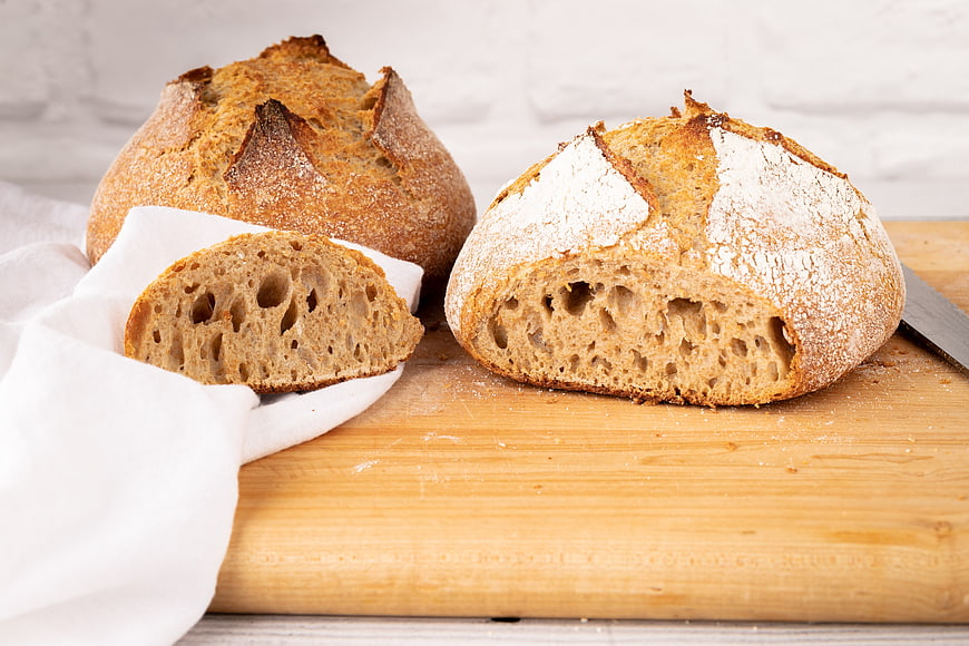 Freshly baked sourdough bread loaves on wooden board