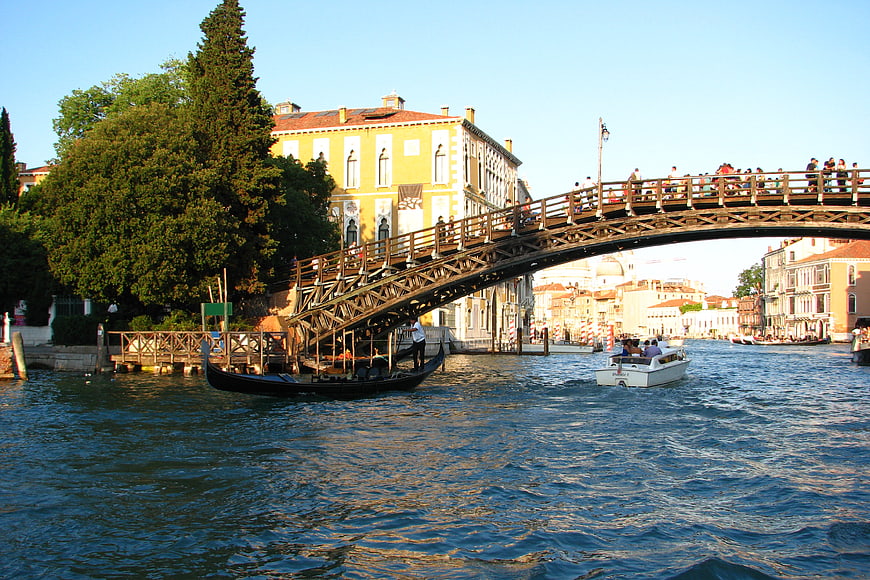 Gondola passing under wooden bridge in Venice canal