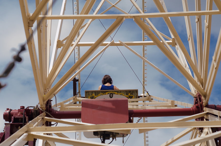 Woman on Ferris Wheel Against Blue Sky