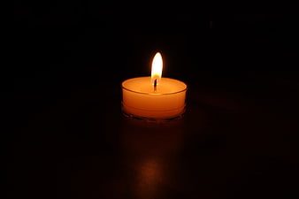 Lit Tea Light Candle in Dark Room