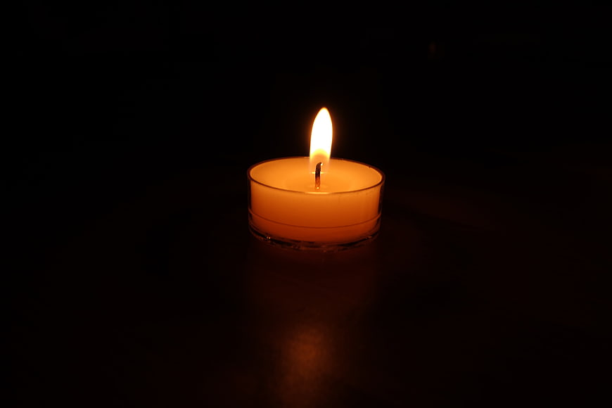 Lit Tea Light Candle in Dark Room