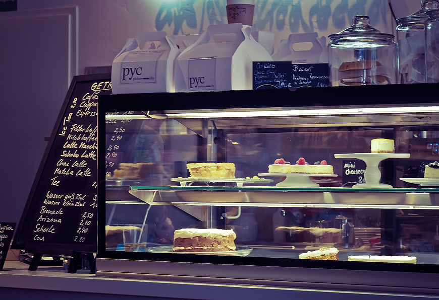 Bakery Display Case With Cakes And Coffee Menu Board