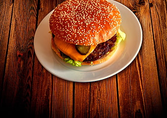 Delicious Cheeseburger on White Plate with Wooden Background