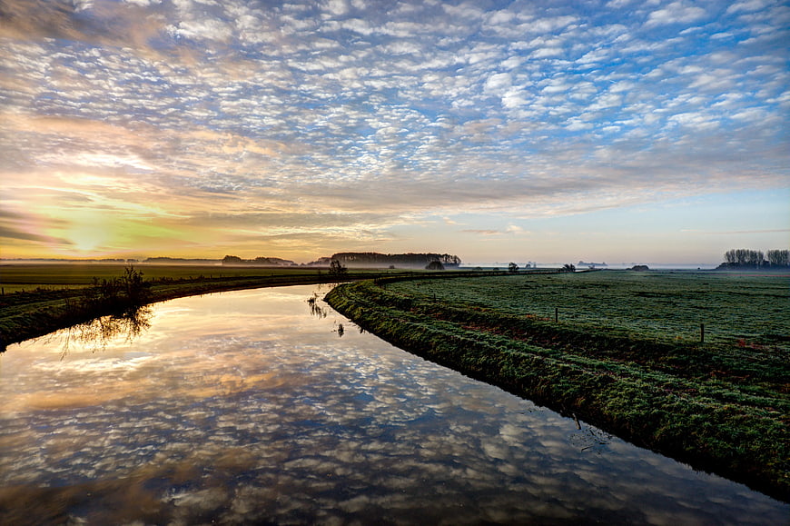 Serene River Landscape with Cirrus Clouds at Sunrise