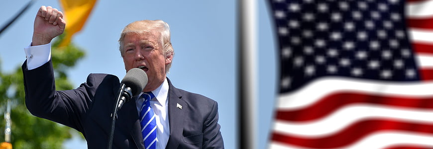 Donald Trump Speaking at Political Rally with American Flag