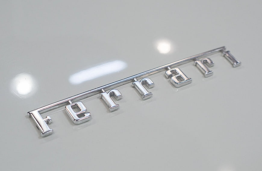 Silver Ferrari Emblem on White Car Hood