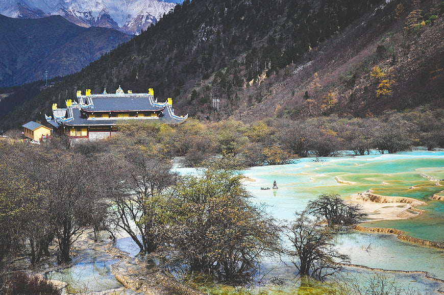 Traditional Chinese Temple Overlooking Turquoise Terraced Pools in Huanglong
