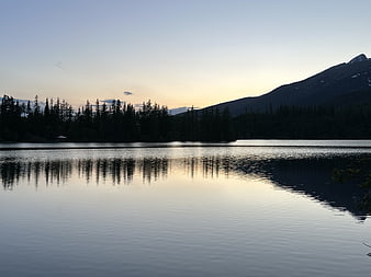 Serene Lake Reflection at Dusk with Mountain Silhouette