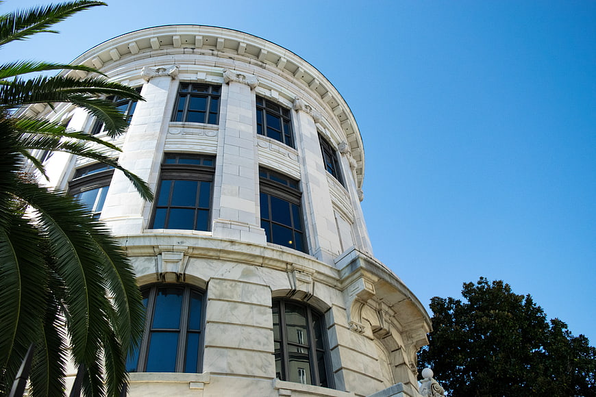 Low angle view of white marble building with palm trees