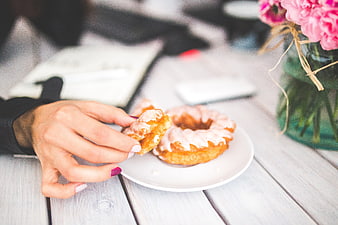 Woman's Hand Holding Glazed Donut on White Plate