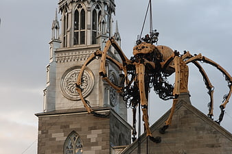 Giant mechanical spider sculpture on church roof