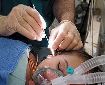 Close-up of doctor performing ear procedure on patient