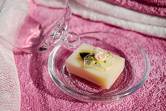Decorative soap bar on glass dish with pink towels