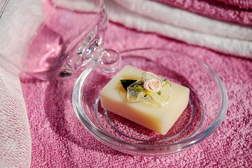 Decorative soap bar on glass dish with pink towels