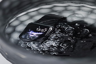 Black Smartwatch Submerged in Water with Bubbles