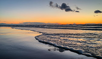 Serene Sunset Beach with Gentle Waves and Reflections