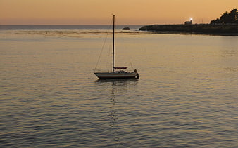 Sailboat Anchored in Calm Bay at Golden Sunset
