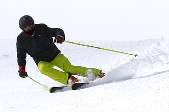 Alpine skier carving a turn on a snowy slope
