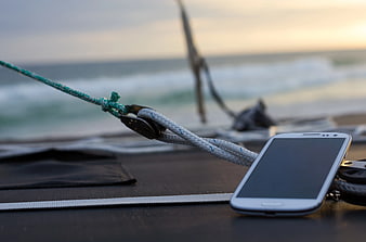 Smartphone on Sailboat Deck with Ocean Background