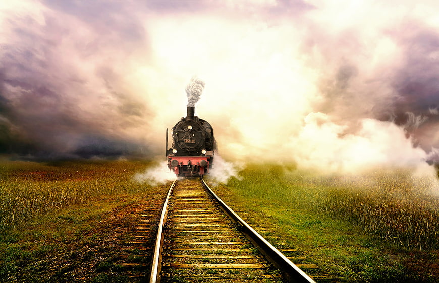 Vintage Steam Train on Tracks in Misty Landscape