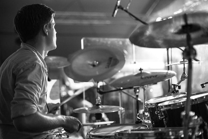 Black and White Profile of Male Drummer Playing Live Concert Drums