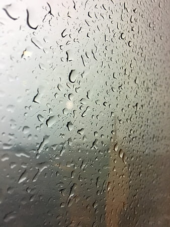 Raindrops on a window glass with blurred background