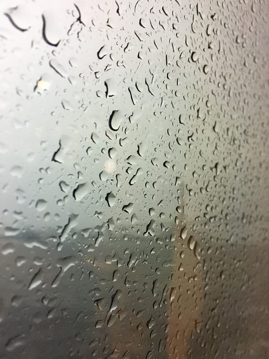 Raindrops on a window glass with blurred background