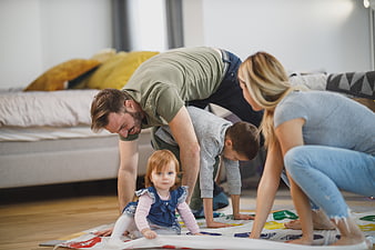 Happy family playing Twister game on living room floor