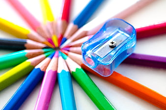 Colorful Pencils Arranged in Circle with Blue Sharpener
