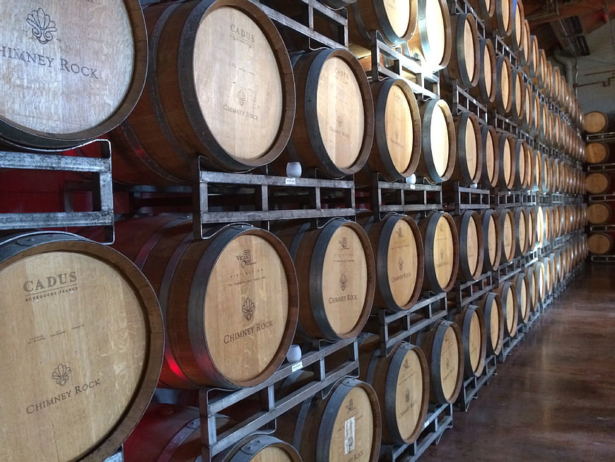Rows of wooden wine barrels in a cellar