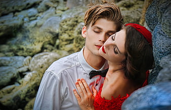 Romantic Couple in Red and White by Rocky Shore