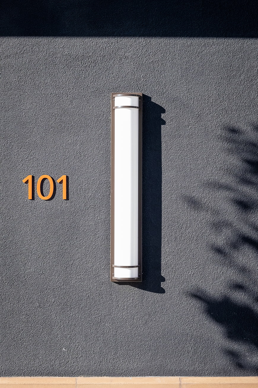 Minimalist Exterior Wall with House Number 101 and Sconce