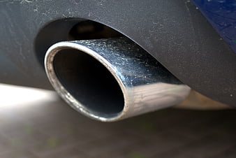 Close-up of a car exhaust pipe with visible wear and grime