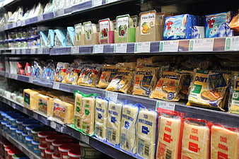 Supermarket dairy aisle with packaged cheese and yogurt