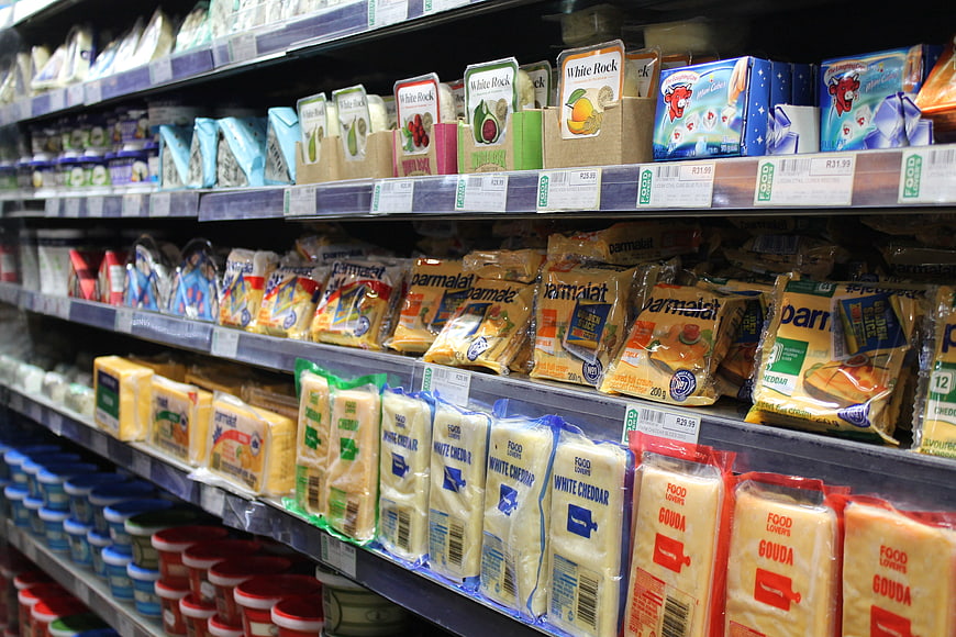 Supermarket dairy aisle with packaged cheese and yogurt