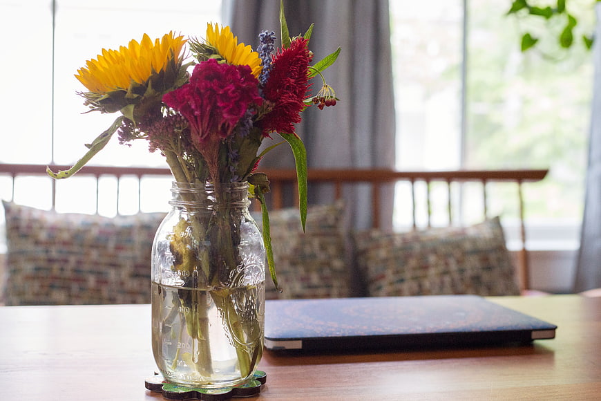 Sunflowers and Red Flowers in Mason Jar on Wooden Table