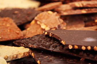 Close-up of assorted chocolate bars with nuts and cocoa nibs