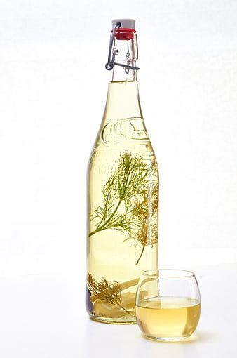 Infused herbal spirit in glass bottle with sprig