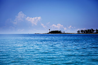 Lighthouse on tropical island with blue ocean and sky